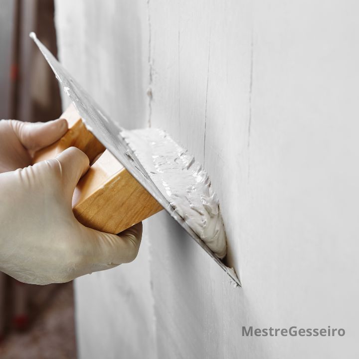 foto de um homem passando gesso na parede em uma casa de contagem